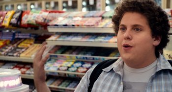 Movie still from “Superbad” (2007), directed by Greg Mottola – A man in a grocery store talking to a camera; Close Up shot, Over the shoulder angle