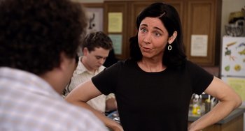 Movie still from “Superbad” (2007), directed by Greg Mottola – A woman standing in front of two other people; Close Up shot, Over the shoulder angle