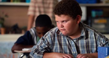 Movie still from “Superbad” (2007), directed by Greg Mottola – A young boy sitting in front of a table; Close Up shot, High angle
