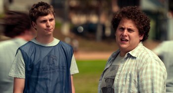 Movie still from “Superbad” (2007), directed by Greg Mottola – Two young men standing next to each other on a field; Close Up shot, Over the shoulder angle