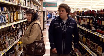 Movie still from “Superbad” (2007), directed by Greg Mottola – A man and a woman in a liquor store; Medium shot, Over the shoulder angle