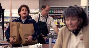 Movie still from “Superbad” (2007), directed by Greg Mottola – A man and a woman in a grocery store with paper bags; Medium shot, Over the shoulder angle