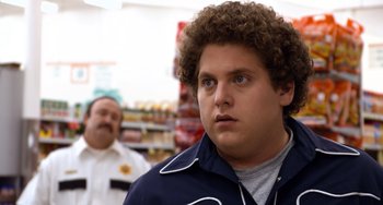 Movie still from “Superbad” (2007), directed by Greg Mottola – A man with a curly brown hair and blue jacket; Close Up shot, Over the shoulder angle