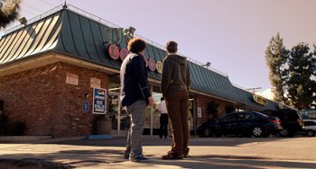 Movie still from “Superbad” (2007), directed by Greg Mottola – Two men standing outside of a store on the sidewalk; Wide shot, Low angle