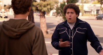 Movie still from “Superbad” (2007), directed by Greg Mottola – Two young men standing next to each other on a sidewalk; Medium shot, Over the shoulder angle