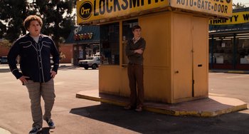 Movie still from “Superbad” (2007), directed by Greg Mottola – A man standing in front of an auto repair shop; Wide shot, Low angle
