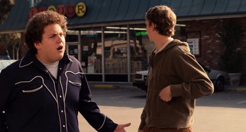 Movie still from “Superbad” (2007), directed by Greg Mottola – Two men talking on the sidewalk in front of a store; Medium shot, Over the shoulder angle
