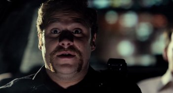 Movie still from “Superbad” (2007), directed by Greg Mottola – A person with a beard and mustache; Close Up shot, Over the shoulder angle