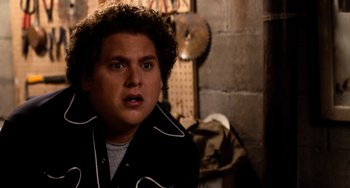 Movie still from “Superbad” (2007), directed by Greg Mottola – A man with curly brown hair wearing a black jacket; Close Up shot, Over the shoulder angle