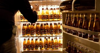 Movie still from “Superbad” (2007), directed by Greg Mottola – A person standing in front of a refrigerator filled with bottles of beer; Extreme Close Up shot, Overhead angle