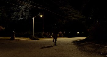 Movie still from “Superbad” (2007), directed by Greg Mottola – A person walking down a street at night; Extreme Wide shot, Low angle