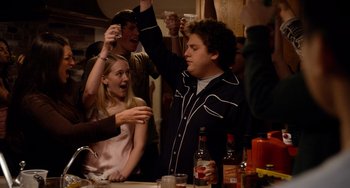 Movie still from “Superbad” (2007), directed by Greg Mottola – A group of people standing around a table with drinks; Medium shot, Over the shoulder angle