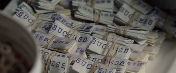 Movie still from “Clean” (2022), directed by Lachlan Mcleod – A pile of money that is tied up with string; Extreme Close Up shot, Overhead angle