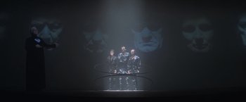 Movie still from “Superman” (1978), directed by Richard Donner – A group of people standing in front of a projection screen; Wide shot, Low angle