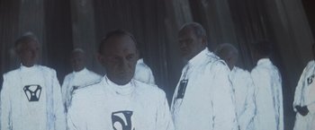 Movie still from “Superman” (1978), directed by Richard Donner – Two men standing next to each other wearing white suits; Medium shot, Low angle