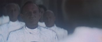 Movie still from “Superman” (1978), directed by Richard Donner – A group of men standing next to each other in a room; Close Up shot, Over the shoulder angle