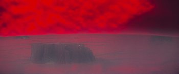 Movie still from “Superman” (1978), directed by Richard Donner – A view of a red sky and a mountain; Extreme Wide shot, High angle