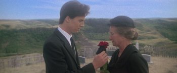Movie still from “Superman” (1978), directed by Richard Donner – A man holding a rose in front of a woman wearing a suit; Close Up shot, Over the shoulder angle