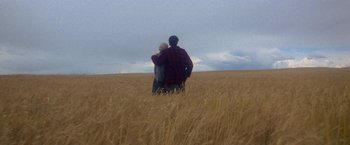 Movie still from “Superman” (1978), directed by Richard Donner – A man and a woman hugging in a field; Wide shot, Low angle