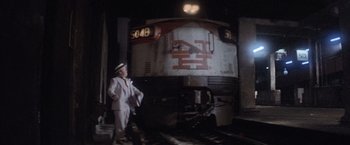 Movie still from “Superman” (1978), directed by Richard Donner – A man standing next to a train on a train track; Wide shot, High angle