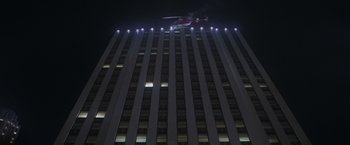 Movie still from “Superman” (1978), directed by Richard Donner – A helicopter flying over a tall building at night; Extreme Wide shot, Low angle