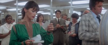 Movie still from “Superman” (1978), directed by Richard Donner – A group of people standing in a room looking at papers; Medium shot, Over the shoulder angle