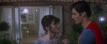 Movie still from “Superman” (1978), directed by Richard Donner – A man and a woman standing next to each other in a room; Close Up shot, Over the shoulder angle