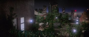Movie still from “Superman” (1978), directed by Richard Donner – A patio area with chairs and a table in the middle of the night; Extreme Wide shot, High angle