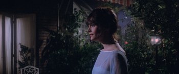 Movie still from “Superman” (1978), directed by Richard Donner – A woman standing in front of a building at night; Medium shot, Over the shoulder angle