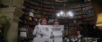Movie still from “Superman” (1978), directed by Richard Donner – Two women are reading a newspaper in a library; Wide shot, Low angle