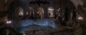 Movie still from “Superman” (1978), directed by Richard Donner – A man is swimming in a pool of water in a building; Extreme Wide shot, High angle