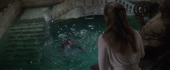 Movie still from “Superman” (1978), directed by Richard Donner – A woman watches a man swimming in a pool; Wide shot, High angle