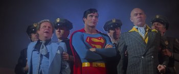 Movie still from “Superman” (1978), directed by Richard Donner – A group of men standing next to each other; Medium shot, Low angle