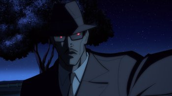 Movie still from “Superman: Man of Tomorrow” (2020), directed by Chris Palmer – A man in a black suit and a red hat; Medium shot, Low angle