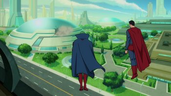 Movie still from “Superman: Man of Tomorrow” (2020), directed by Chris Palmer – Two people standing on the side of a road looking out over a city; Extreme Wide shot, High angle