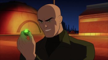 Movie still from “Superman: Man of Tomorrow” (2020), directed by Chris Palmer – A bald man holding a green object in his hand; Close Up shot, Over the shoulder angle