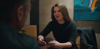 Movie still from “Superpower” (2023), directed by Aaron Kaufman – A woman sitting at a table talking to a man; Close Up shot, Over the shoulder angle