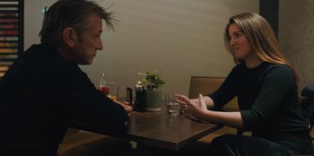 Movie still from “Superpower” (2023), directed by Aaron Kaufman – A man and a woman sitting at a table with drinks; Medium shot, Over the shoulder angle