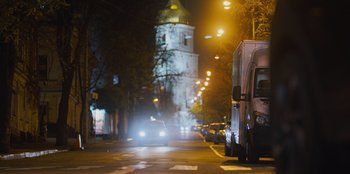 Movie still from “Superpower” (2023), directed by Aaron Kaufman – A van is driving down the street at night; Wide shot, Low angle