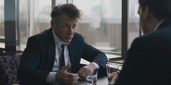Movie still from “Superpower” (2023), directed by Aaron Kaufman – A man sitting at a table talking to another man; Close Up shot, Over the shoulder angle