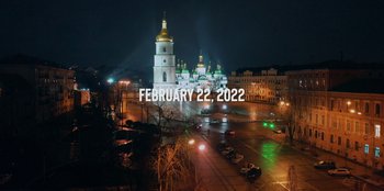 Movie still from “Superpower” (2023), directed by Aaron Kaufman – A city street at night with a church in the background; Extreme Wide shot, High angle