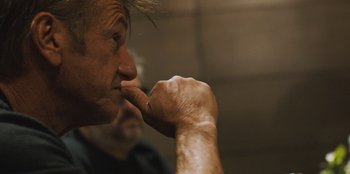 Movie still from “Superpower” (2023), directed by Aaron Kaufman – An older man with a finger in his mouth; Close Up shot, Over the shoulder angle