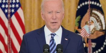 Movie still from “Superpower” (2023), directed by Aaron Kaufman – A person wearing a suit and tie; Close Up shot, Low angle