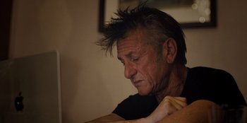 Movie still from “Superpower” (2023), directed by Aaron Kaufman – An older man sitting in front of a table; Close Up shot, Low angle