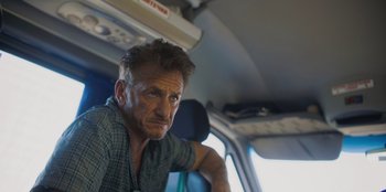 Movie still from “Superpower” (2023), directed by Aaron Kaufman – A person sitting in a car; Close Up shot, Low angle