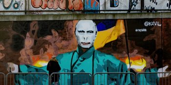 Movie still from “Superpower” (2023), directed by Aaron Kaufman – A painting of a man with a white mask on his face; Medium shot, Low angle