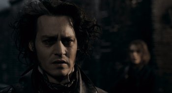 Movie still from “Sweeney Todd: The Demon Barber of Fleet Street” (2007), directed by Tim Burton – A person with long black hair; Close Up shot, Over the shoulder angle
