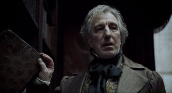 Movie still from “Sweeney Todd: The Demon Barber of Fleet Street” (2007), directed by Tim Burton – An older man in a suit and tie holding a cigarette; Close Up shot, Low angle