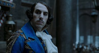 Movie still from “Sweeney Todd: The Demon Barber of Fleet Street” (2007), directed by Tim Burton – A man in a blue and white jacket and a white bow tie; Close Up shot, Low angle