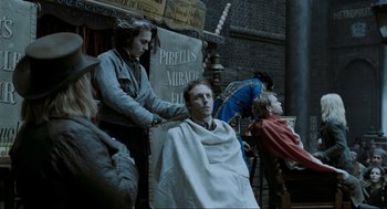 Movie still from “Sweeney Todd: The Demon Barber of Fleet Street” (2007), directed by Tim Burton – A man getting his hair combed by a woman; Medium shot, Over the shoulder angle
